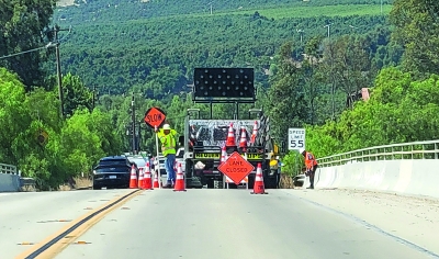 On Friday, September 13, 2024, traffic was delayed for work on Old Telegraph Road which was closed down to one lane due to the Ventura County Transportation Commission doing emergency repairs on the embankment along the Sespe Creek. Photo credit Angel Esquivel. Inset photo Gazette staff.