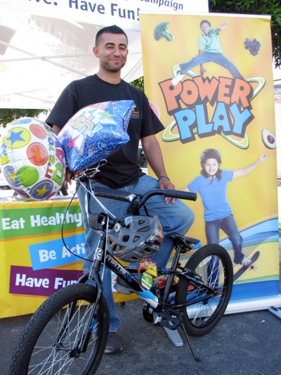 Ivan Medina from the Network for a Healthy California displays bike and bike helmet, the prize for the passport drawing. One of the Sespe Elementary after school program students won this prize at the drawing!