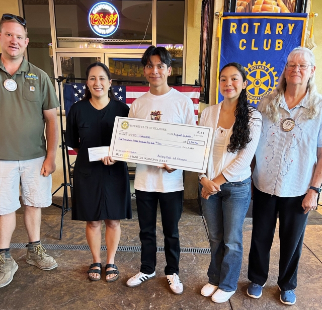 On Wednesday, August 21, Rotary Club of Fillmore recognized Kim Tafoya, a coach for 22 years, and two of her players, FHS Seniors Harriers Omar Heredia and Diana Santa Rosa were the Rotary program speakers. Kim and her students worked on and at the 5/10K Run Fundraiser. They split the profits of the event and Cindy Blatt and Andy Klittich presented them with a check for $5,310.56. Pictured (l-r) are Andy Klittich, Kim Tafoya, Omar Heredia, Diana Santa Rosa and Cindy Blatt. Photo credit Martha Richardson.