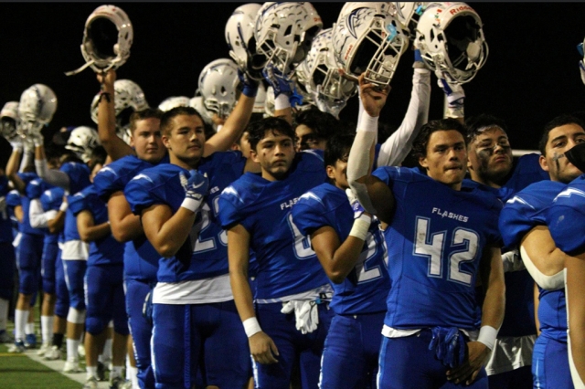 The Flashes raising their helmets for the national anthem before a home playoff game against Coachella Valley. Photo Courtesy Crystal Gurrola.