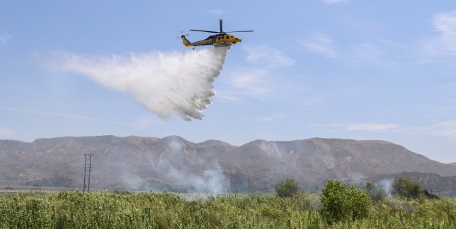 On Wednesday, August 7, 2024, at 12:04 p.m., Fillmore City Fire Department and the Ventura County Fire Department responded to a reported brush fire in the Santa Clara riverbed. The fire was blazing in the river near the A Street Bridge. Smoke and flames could be seen coming from the Arundel. A helicopter from the Sheriff’s Air Unit responded with multiple water drops. The brush fire spread to at least one acre; cause is under investigation. Photo credit Angel Esquivel.