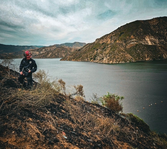 A Sheriff’s Bomb Squad Arson Investigator inspects a 1-acre burn area near Lake Piru Dam on Monday.