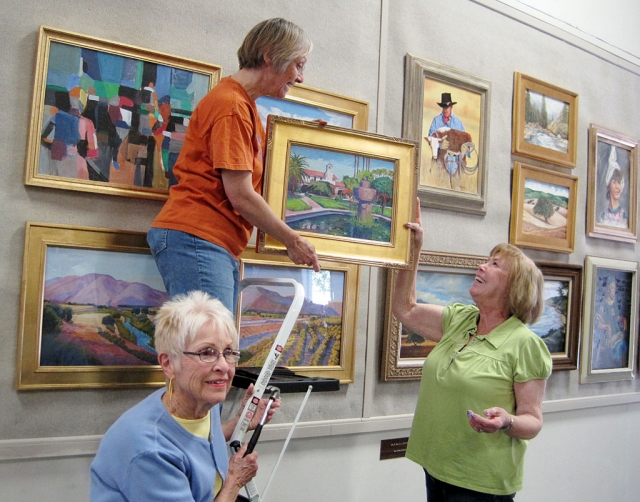 Some of the Artists Guild members hang artwork for the public to enjoy.