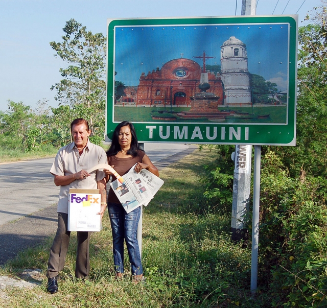 Another photo of John next to the Tumauini road sign with Ester.