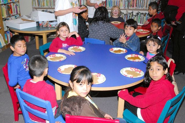 What more could you ask for? The Friends of the Library hosted an Annual Open House at the Fillmore Library on Wednesday, December 16th, much to the delight of local children. Shown are a few of the visitors enjoying some Christmas cookies.