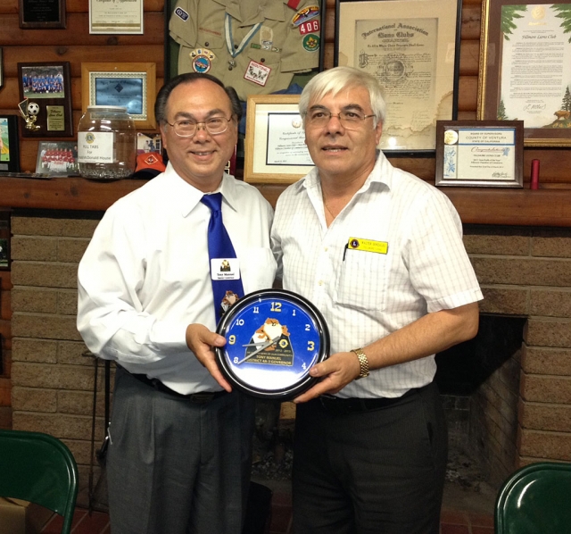 Lion’s Club District 4-A3 District Governor Tony Manuel of Santa Maria made his annual visit to the Fillmore Lion’s Club on Monday, October 1.  After his inspirational remarks to the club gathering, Fillmore Lion’s President Walter presented Manuel with a special clock on behalf of the club.  The clock features Manuel’s insignia for this year, including a Tasmanian Devil.  There were members of other area clubs also on hand for the dinner and presentation by Manuel.  As Manuel said in a recent District Newsletter, My theme this year is, “We are the Gems of our Community” and by working together we will shine and sparkle and stand out from the other organizations, so we will be better recognized and appreciated in our communities.