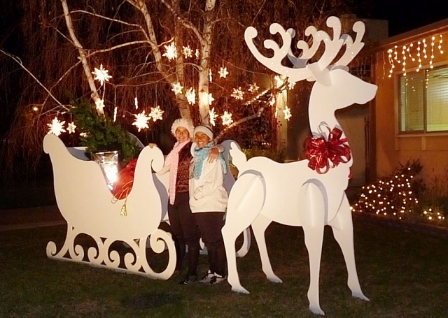 When twins Sierra and Bailey Huerta heard that their Aunt Margo would be in town for Thanksgiving but not Christmas, they determined to do something special for her and celebrate Christmas a little early. With the help of their Grandma Jeannie, they made plans to construct a 9’ tall reindeer and an 8’ long Santa’s sleigh. The plywood, screws and paint were assembled. Nearly one month later the job was complete. The girls ran the saws, drilled the holes and painted the project. It went up the day before Thanksgiving and can be seen on Shiells Drive. When Margo saw the decoration she remarked that “These two girls can do just about anything”.