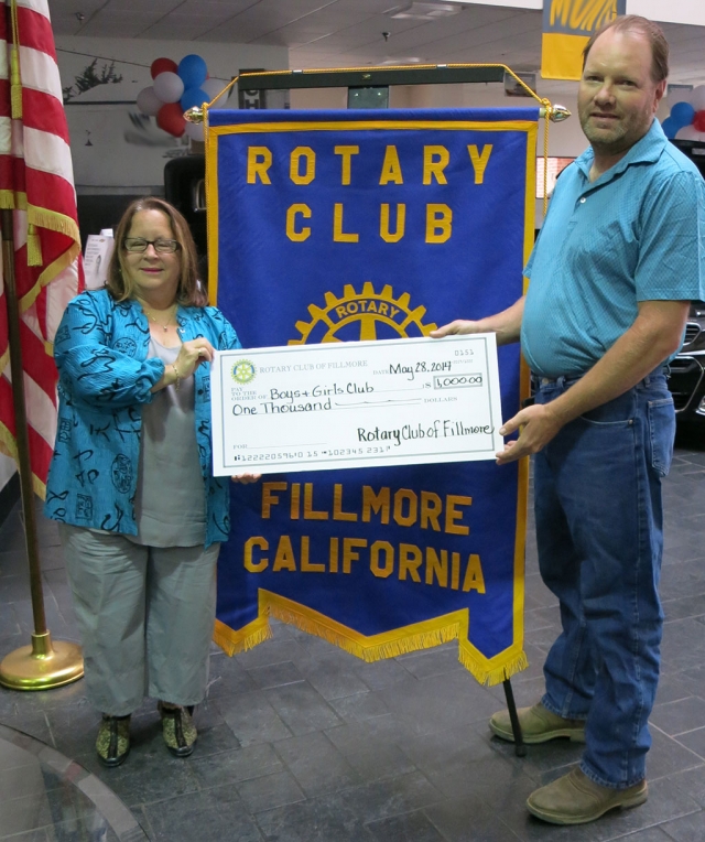 Jan Marholin is presented with a check for $1,000 for the Boys & Girls Club. Scott Beylik presented the check from the Rotary Club of Fillmore.