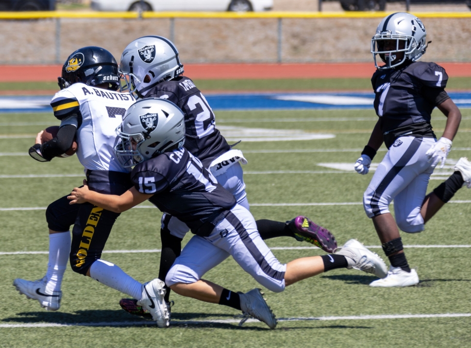 Above is a group of Raiders Bantam Black players trying to take down a North Valley Golden Bear player to keep him from gaining yards. Photo credit Crystal Gurrola.